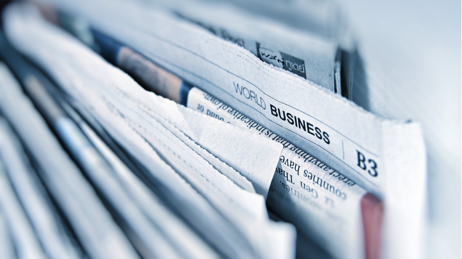 Collection of newspapers with the world business section visible