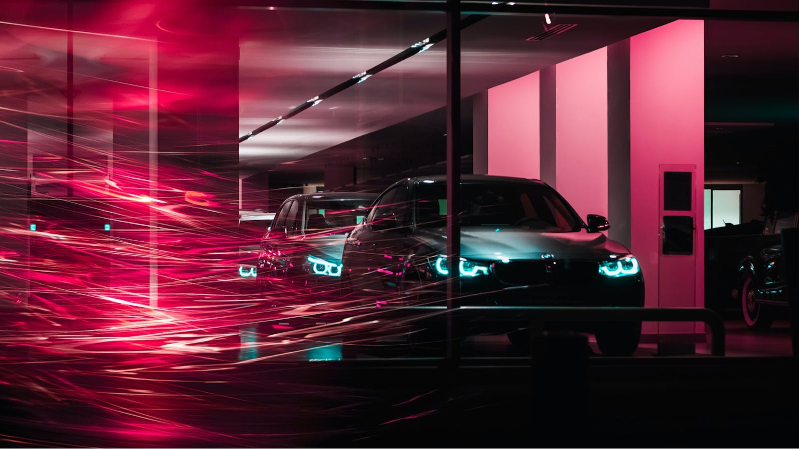 Cars in a dealership with neon lights in the foreground