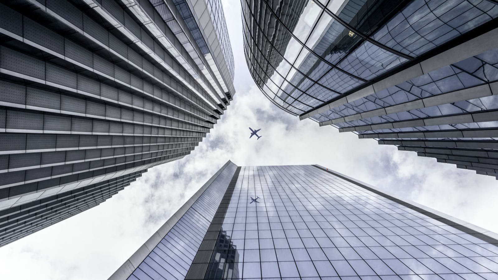 Image of a plane between buildings from a worm view